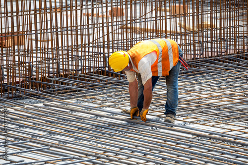 Construction worker installing floor slab reinforcement bars photo