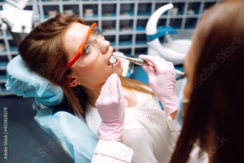 Photographie Young woman opening her mouth wide during treating her teeth by the dentist