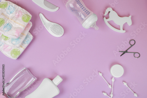 Baby accessories on purple background, flat lay. Composition with baby accessories and space for text. 