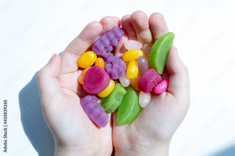 hands holding colorful candies hands holding colorful candies