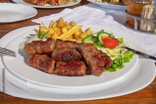 Balkan cuisine. Cevapi - grilled dish of minced meat - with vegetables