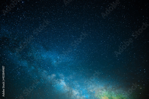 Milky Way. Night starry sky. light nebula, clouds. Shimmering blue tones. Orange glow in the sky. Blank space for your signature. Background. Texture. Color photo. © Anton