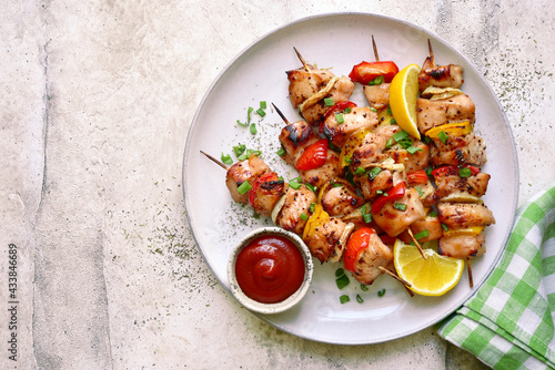 Фотография Chicken kebab skewers on a plate . Top view with copy space.