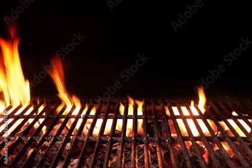 Barbecue Fire Grill Isolated On Black Background. BBQ Flaming Grill Background Isolated. Hot Barbeque Charcoal Cast Iron Grill With Bright Flames.