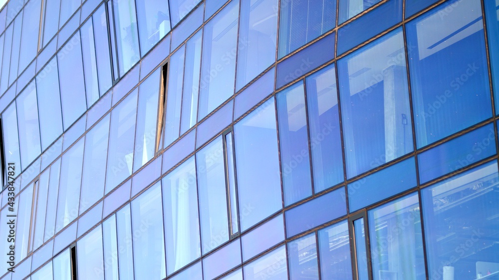 Mirrored windows of the facade of an office building. Abstract texture of blue glass modern office building. Business background.