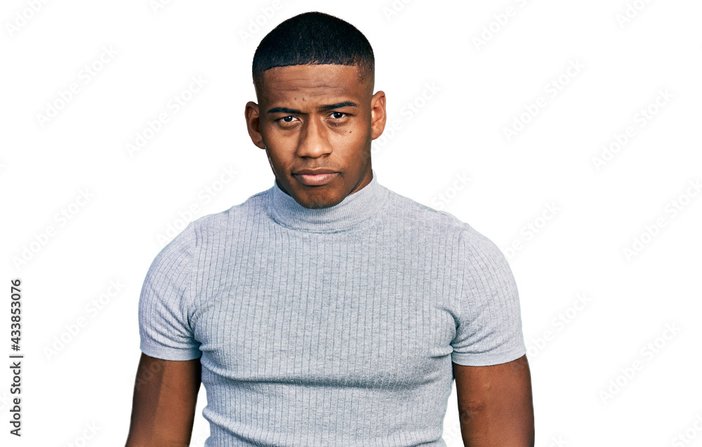 Young black man wearing casual t shirt relaxed with serious expression on face. simple and natural looking at the camera. Young black man wearing casual t shirt relaxed with serious expression on face. simple and natural looking at the camera.