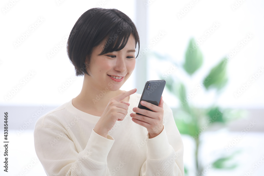 スマートフォンを操作する女性社員 スマートフォンを操作する女性社員