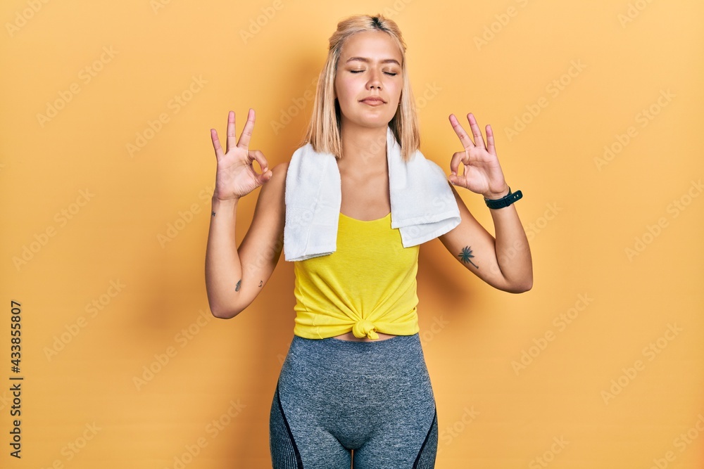 Beautiful blonde sports woman wearing workout outfit relaxed and smiling with eyes closed doing meditation gesture with fingers. yoga concept. Beautiful blonde sports woman wearing workout outfit relaxed and smiling with eyes closed doing meditation gesture with fingers. yoga concept.