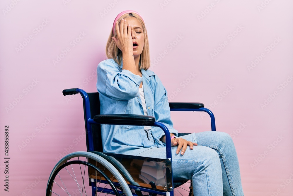 Beautiful blonde woman sitting on wheelchair yawning tired covering half face, eye and mouth with hand. face hurts in pain. Beautiful blonde woman sitting on wheelchair yawning tired covering half face, eye and mouth with hand. face hurts in pain.