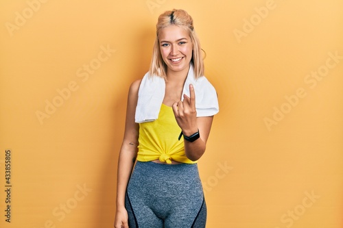 Beautiful blonde sports woman wearing workout outfit beckoning come here gesture with hand inviting welcoming happy and smiling