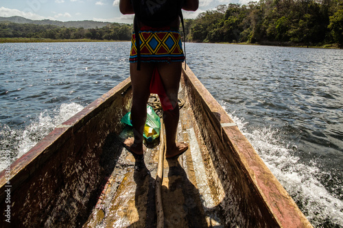 Indígenas de la Etnia Embera Querá de Panamá navegando en su canoa photo