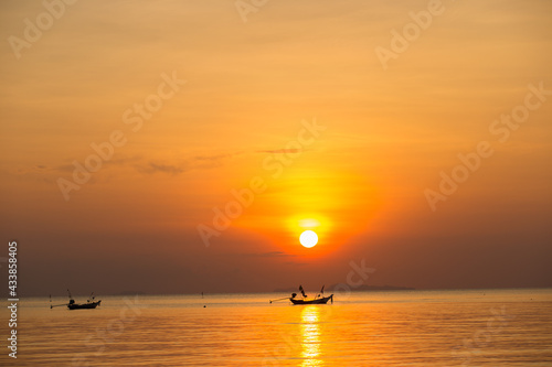 A boat floating in the sea for fishing in the sunset.