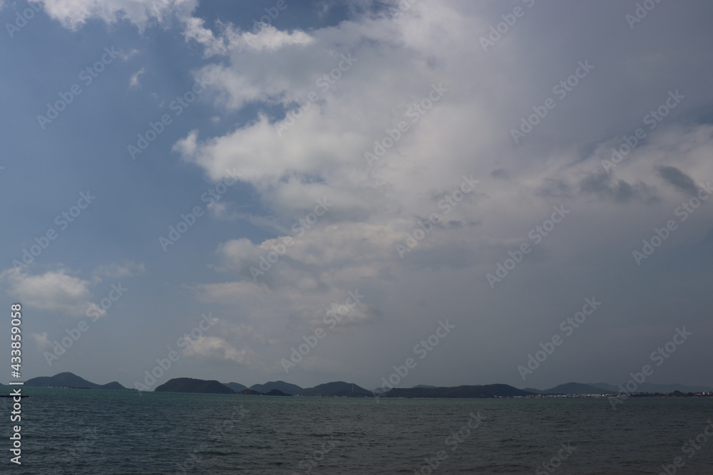 Calm sea There are many mountains and islands, the rain is about to fall like a storm, the sky has many clouds, and the wind is strong. Place for travel and vacation. In Chonburi Province, Thailand