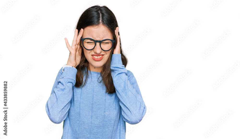 Young beautiful woman wearing casual clothes and glasses with hand on head, headache because stress. suffering migraine. Young beautiful woman wearing casual clothes and glasses with hand on head, headache because stress. suffering migraine.