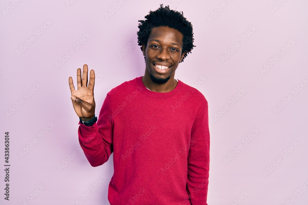 Young african american man wearing casual clothes showing and pointing up with fingers number four while smiling confident and happy. Young african american man wearing casual clothes showing and pointing up with fingers number four while smiling confident and happy.