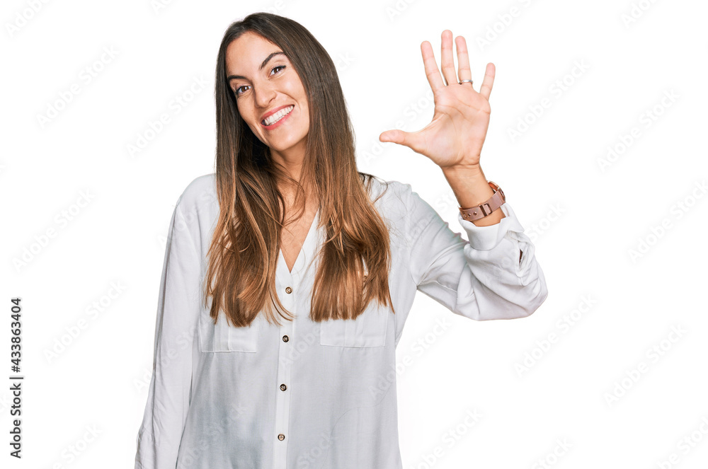 Young beautiful woman wearing casual clothes showing and pointing up with fingers number five while smiling confident and happy. Young beautiful woman wearing casual clothes showing and pointing up with fingers number five while smiling confident and happy.