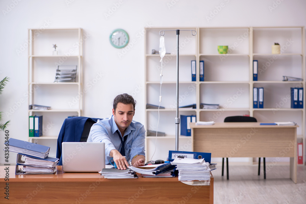 Young male employee suffering at workplace Young male employee suffering at workplace