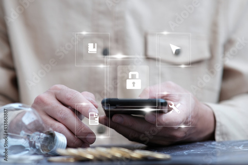 Online data protection and information security concept, cybersecurity, businessman working on smartphone, select the icon security on virtual screen