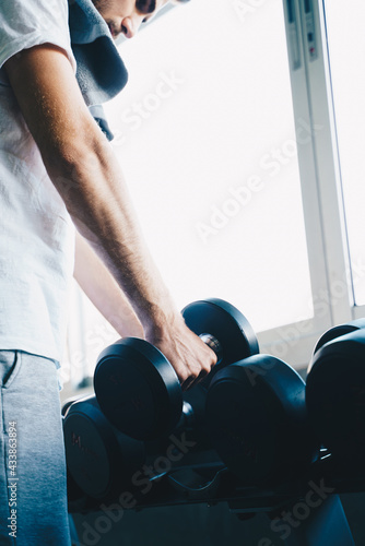 Smart sport man lifting dumbbell up in fitness gym wellnes activity