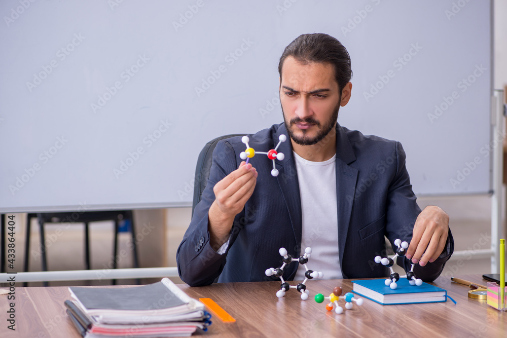 Young male teacher physicist in the classroom Young male teacher physicist in the classroom