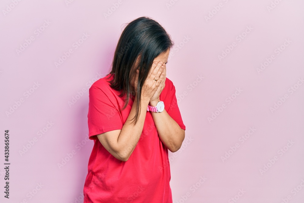 Middle age hispanic woman wearing casual clothes with sad expression covering face with hands while crying. depression concept. Middle age hispanic woman wearing casual clothes with sad expression covering face with hands while crying. depression concept.