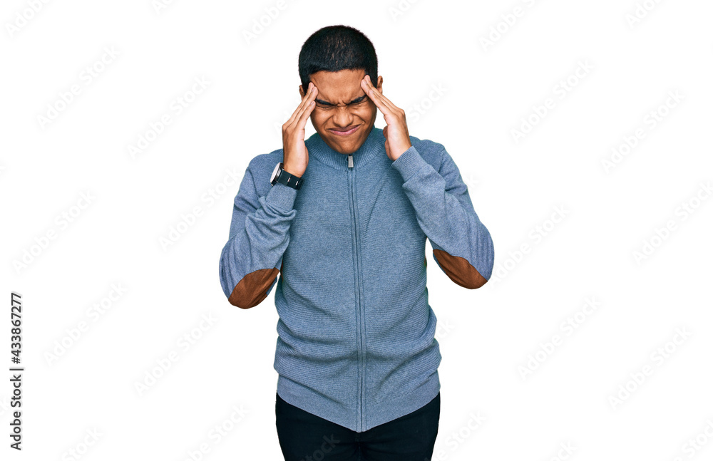 Young handsome hispanic man wearing casual sweatshirt with hand on head, headache because stress. suffering migraine. Young handsome hispanic man wearing casual sweatshirt with hand on head, headache because stress. suffering migraine.