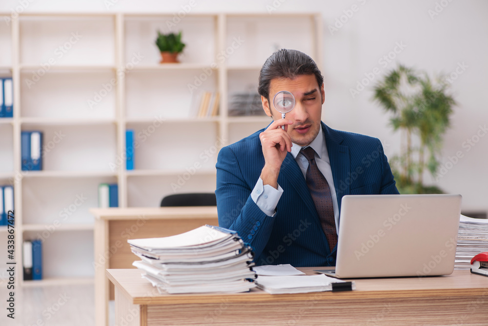 Young male employee unhappy with excessive work Young male employee unhappy with excessive work