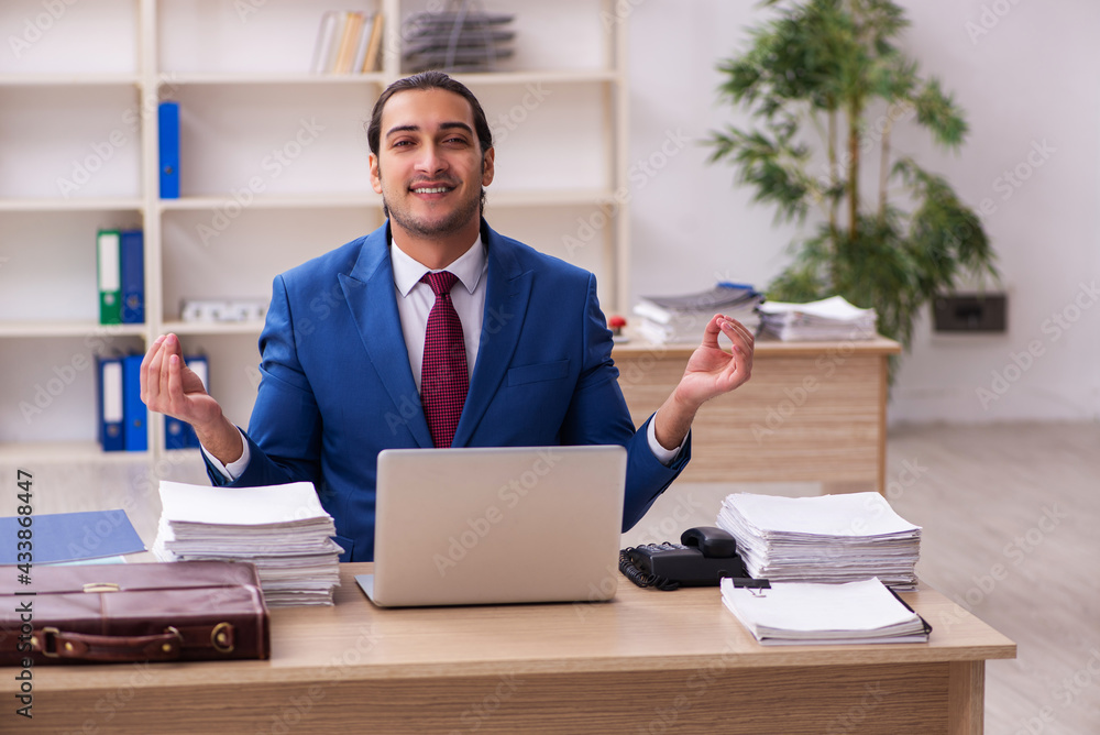 Young male employee doing yoga exercises during break