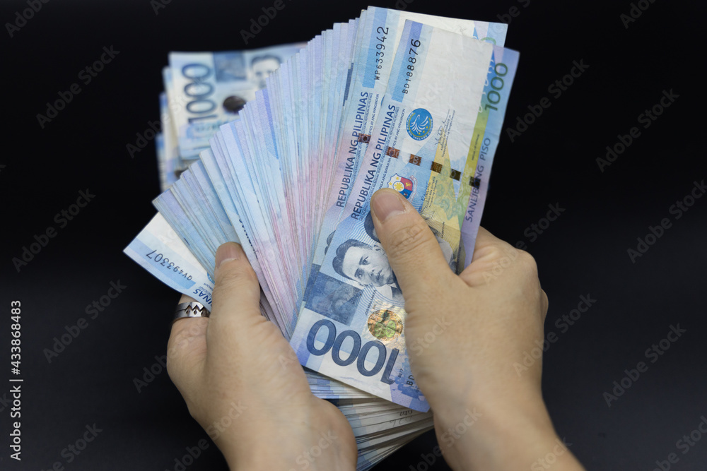 A pile of one thousand Philippines banknotes. Cash of Thousand