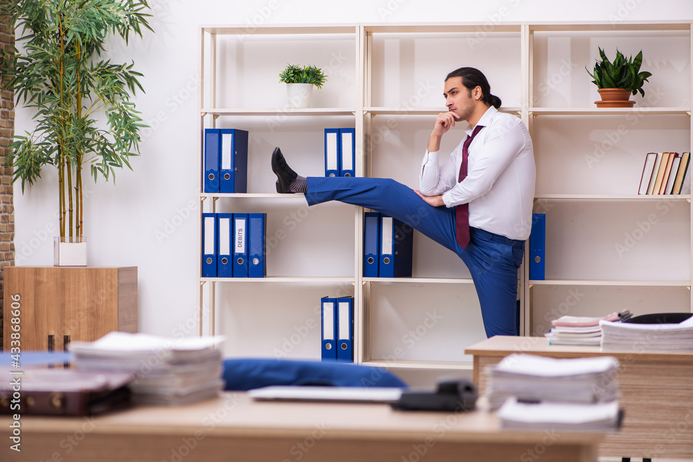 Young male employee doing sport exercises during break Young male employee doing sport exercises during break