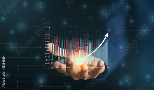Businessman or trader is showing a growing virtual hologram stock, invest in trading.planning and strategy, Stock market.