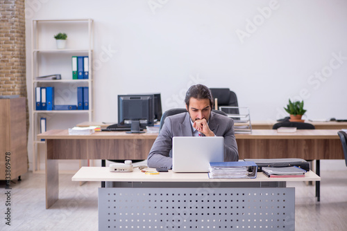 Young male employee working in the office © Elnur
