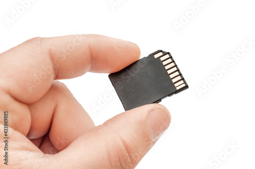 Hand holding SD card. Isolated on white.