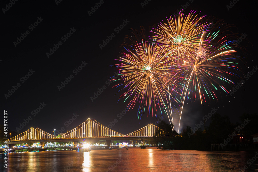 Naklejka premium SURATTHANI, THAILAND - OCTOBER 17 : Beautiful firework display for celebration on the Tapee river on parades in Chak Phra Festival on October 17, 2015 in Suratthani, Thailand.