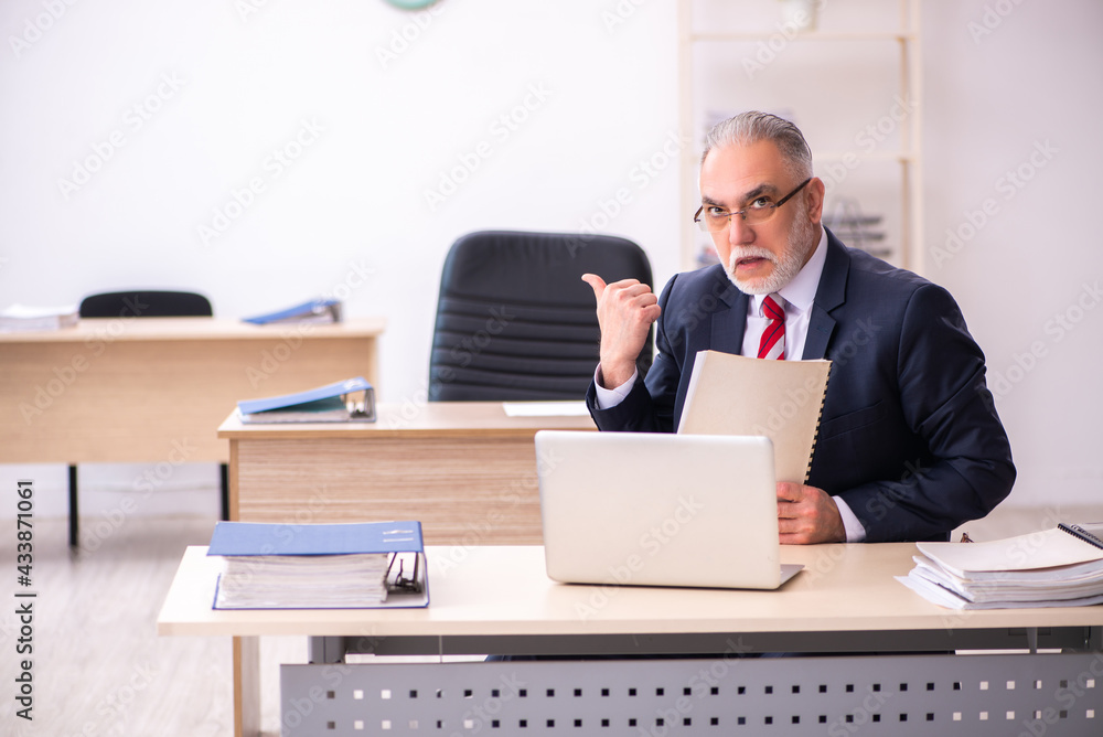 Old businessman employee sitting in the office Old businessman employee sitting in the office