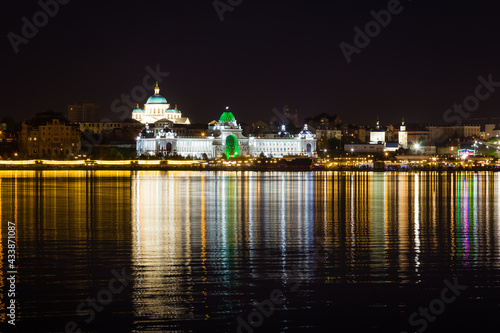 The beautifully illuminated embankment is reflected in the Kazanka River in the city of Kazan on a clear warm summer night