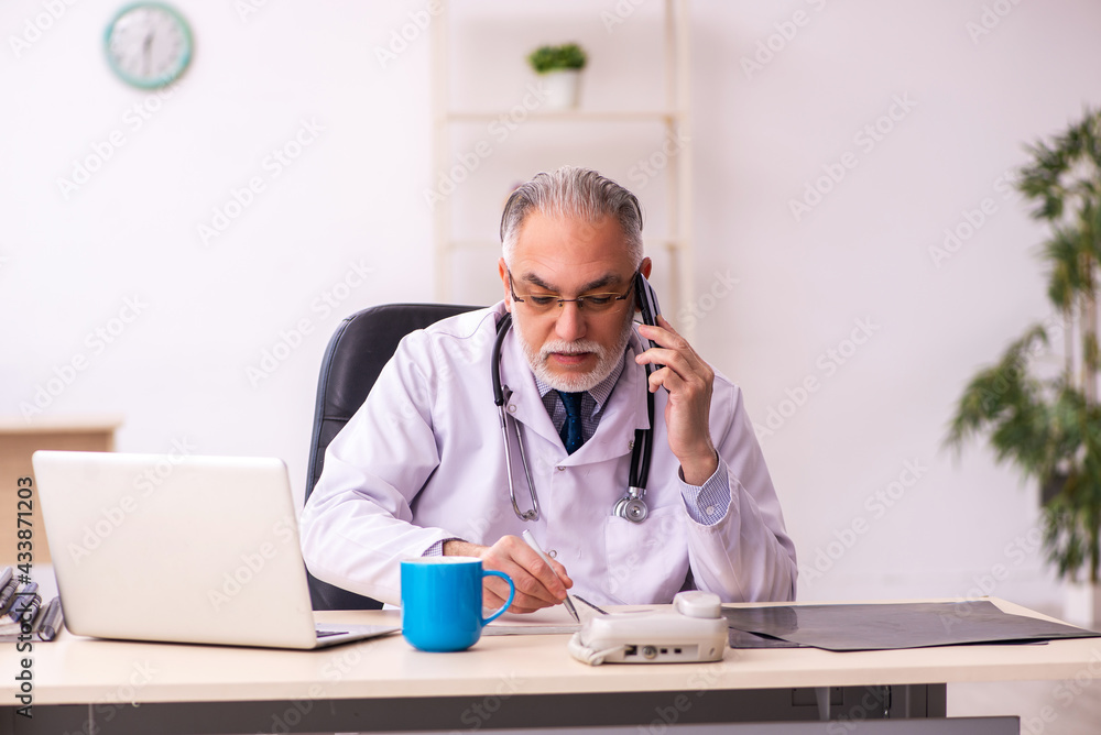 Aged male doctor working in the clinic Aged male doctor working in the clinic