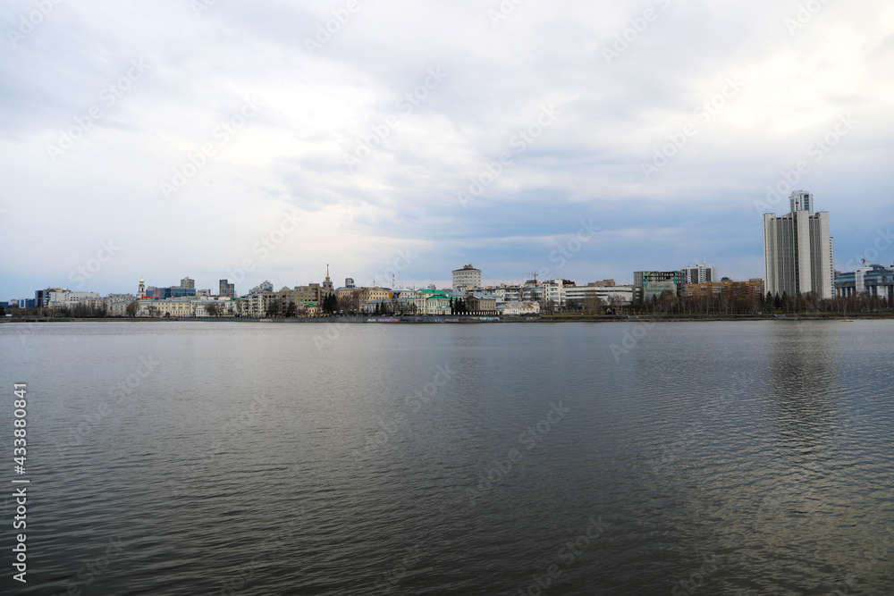 Fototapeta premium City on the background of water in the evening. View from the embankmen