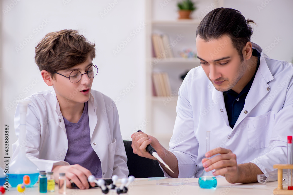 Young father and son chemists in the lab Young father and son chemists in the lab