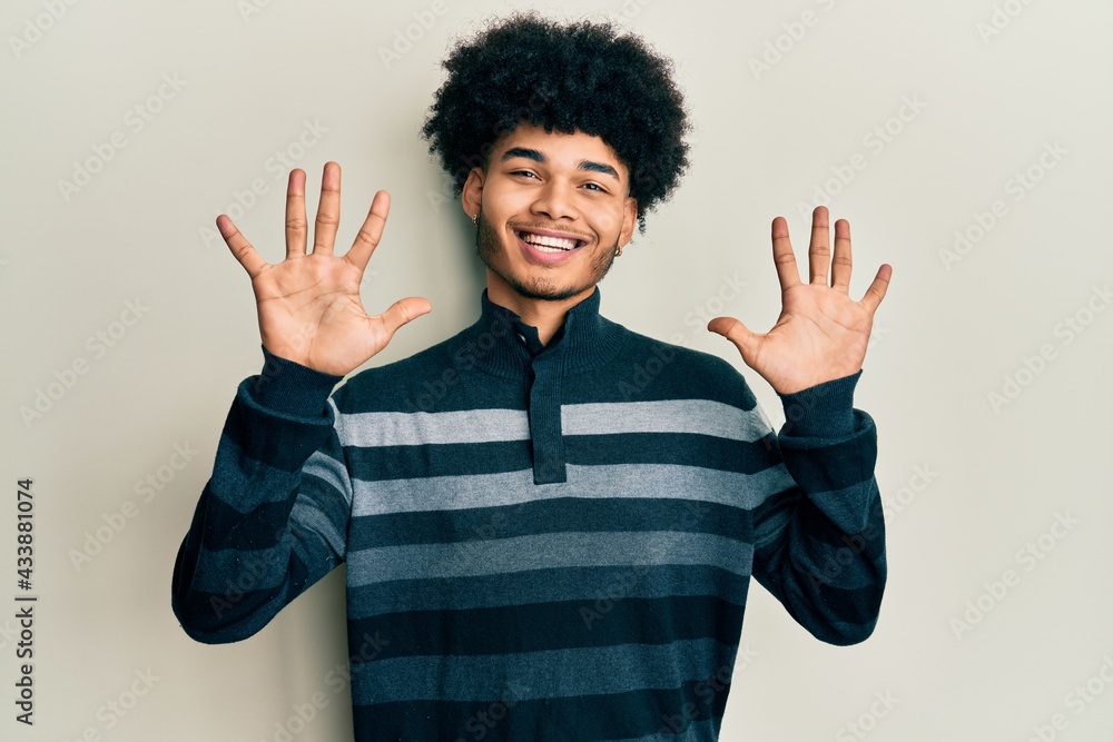 Young african american man with afro hair wearing casual clothes showing and pointing up with fingers number ten while smiling confident and happy. Young african american man with afro hair wearing casual clothes showing and pointing up with fingers number ten while smiling confident and happy.