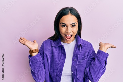 Young brunette woman wearing casual clothes celebrating crazy and amazed for success with arms raised and open eyes screaming excited. winner concept