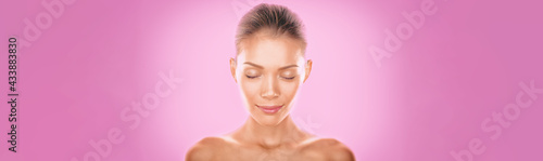 Natural Asian beauty woman model zen with closed eyes meditating calm on pink background. Young girl with slight smile pensive relaxing. Skincare clear dewy skin concept panoramic banner. photo