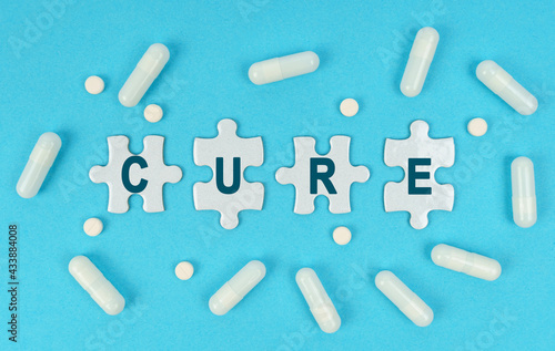 On a blue background, there are pills and puzzles with the inscription - CURE