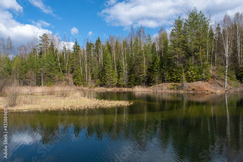 A small lake with high steep banks on a sunny spring day.