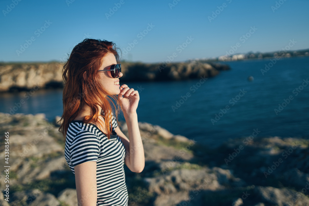 portrait of a beautiful woman in glasses near the lake in the mountains on nature vacation model