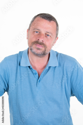 handsome mature man posing in blue shirt on white studio background