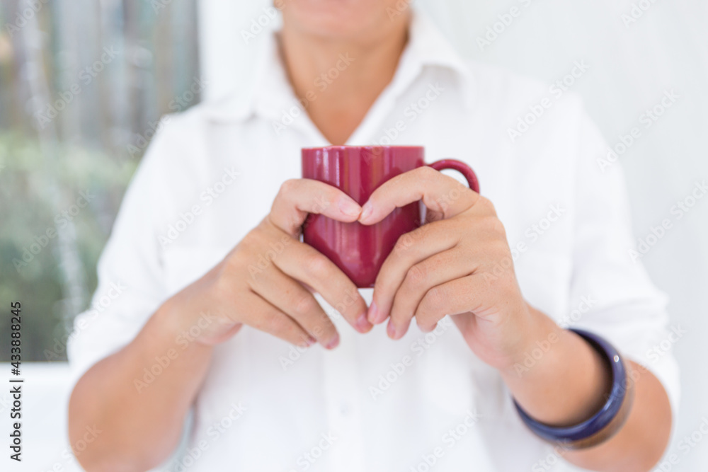 Woman's hands holding a cup. Red cup