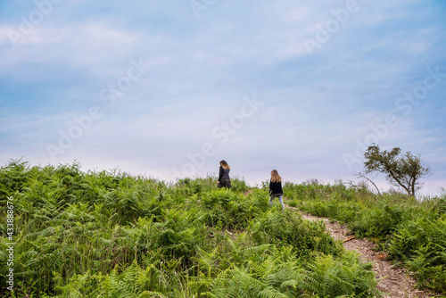 cute young girl and her mom walking in a beautiful forest © Image'in