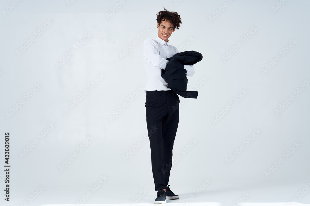 curly guy in suit jacket in hands posing lifestyle modern style curly guy in suit jacket in hands posing lifestyle modern style