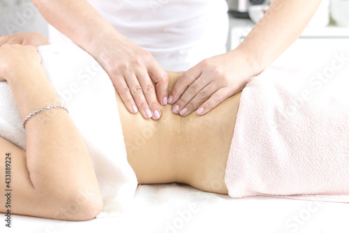 Massage the body, arms, legs, back, abdomen in the massage room with the hands of a specialist with oil with a copy of the space. The concept of professional body care.
